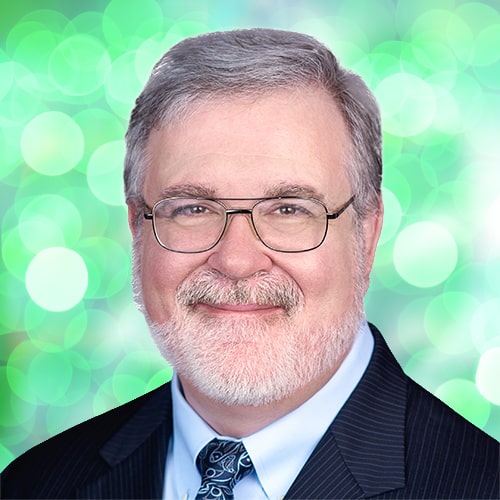 white haired man in suit and glasses