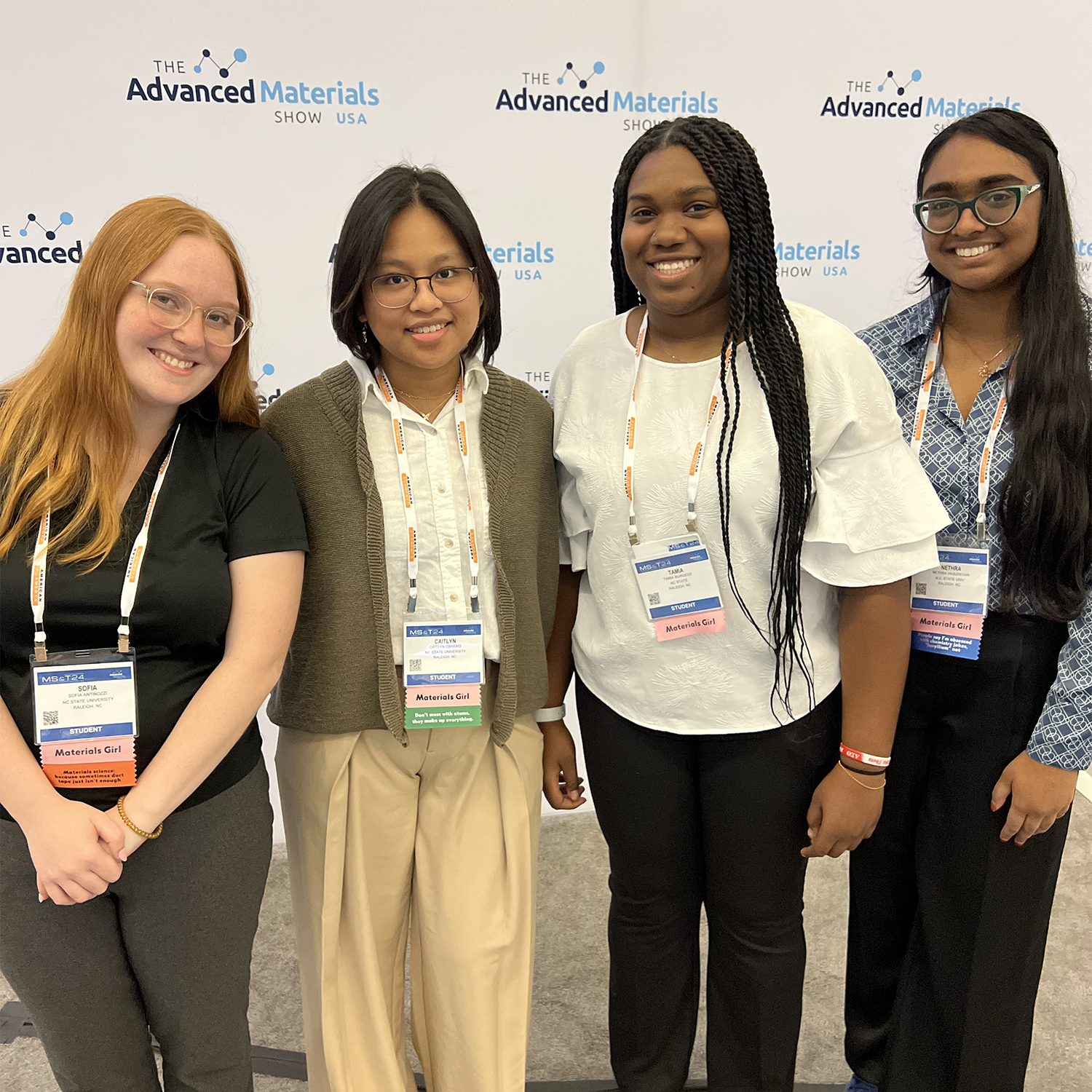 4 female college aged students in a diverse group at a conference