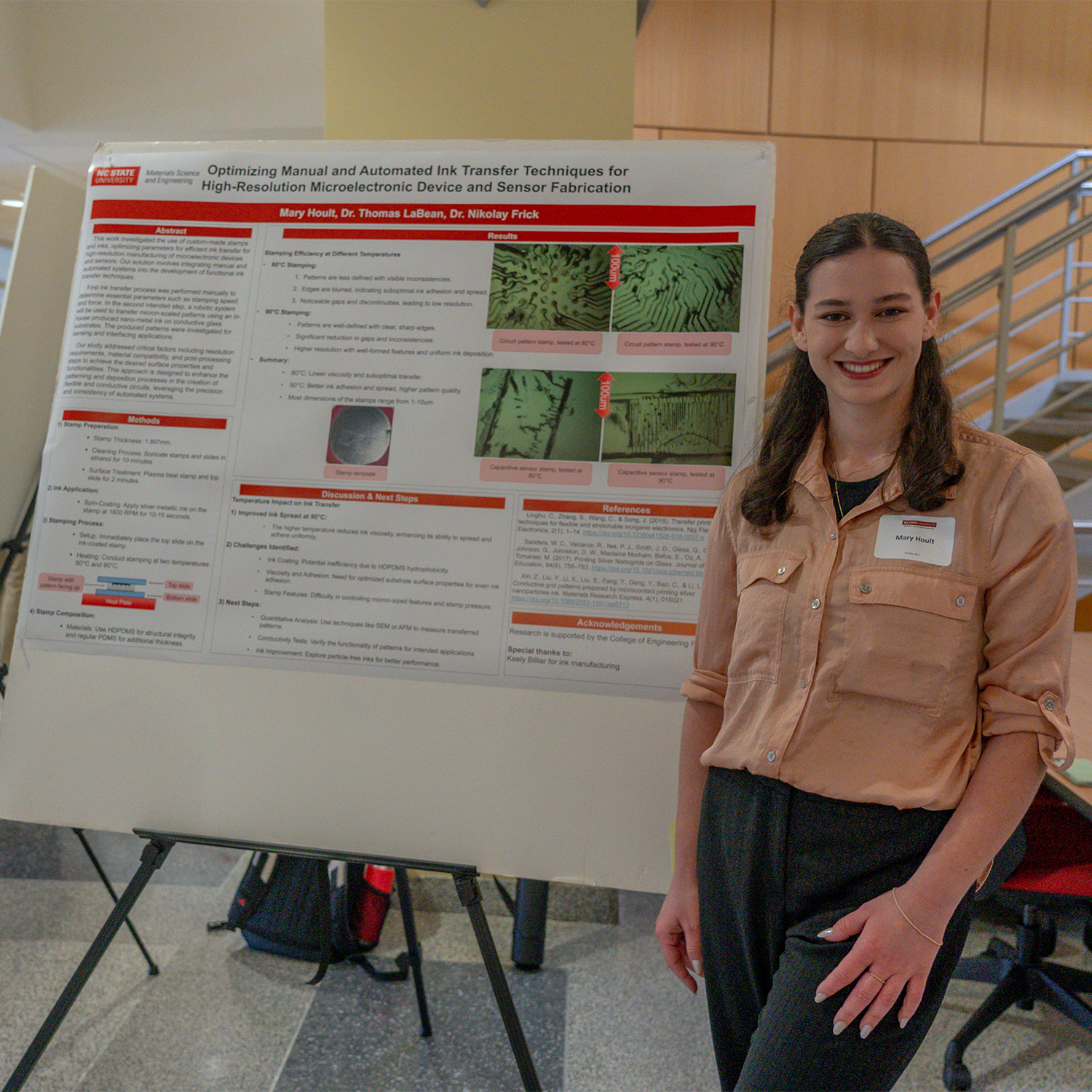 brunette female college student presents scientific poster