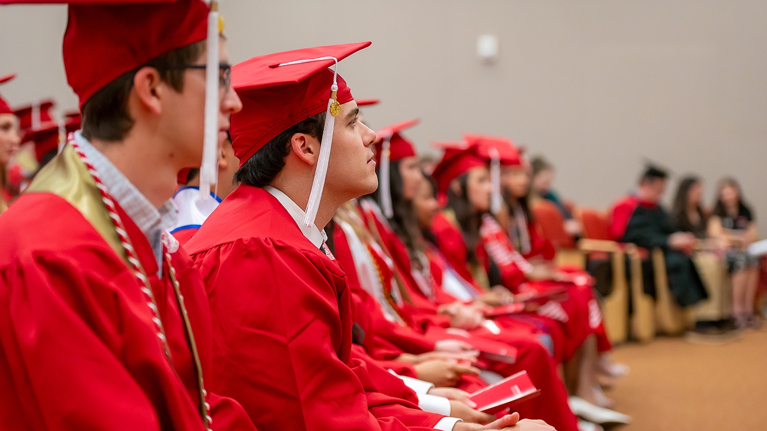 graduates in red caps and gowns